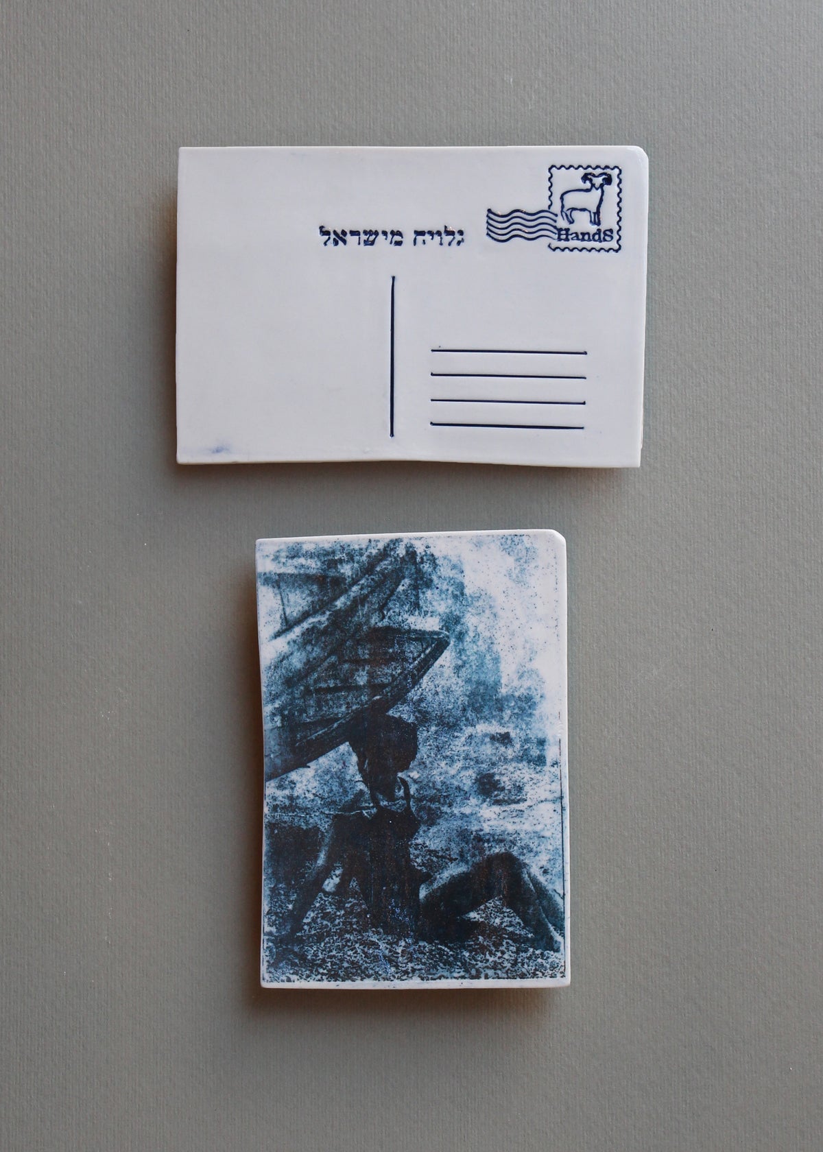 אשה יושבת על החוף ומאחוריה סירה, בול מזל טלה